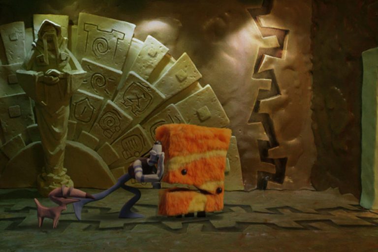 Tommynaut pushes an orange creature in an official Armikrog screenshot