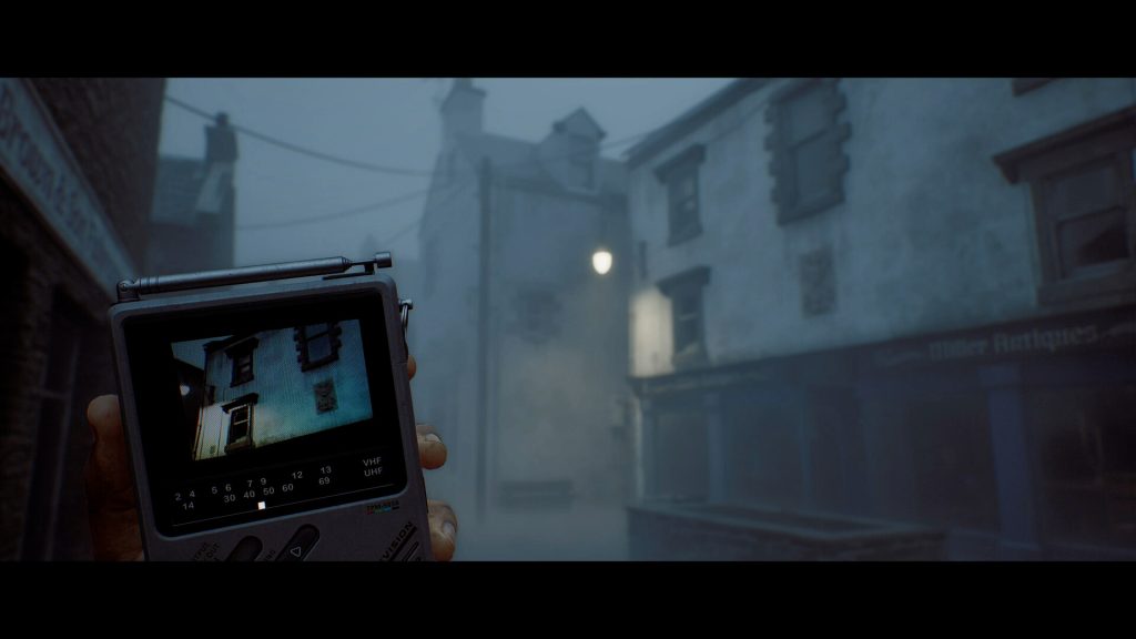 Official SILENT HILL: Townfall screenshot of Simon holding the CRTV on a foggy St. Amelia street