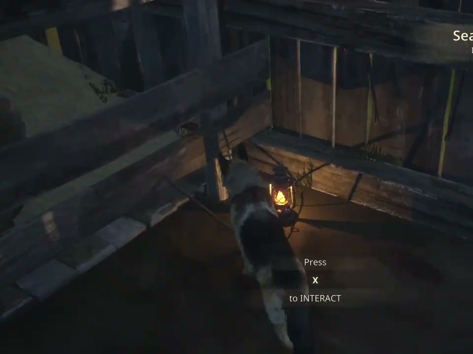 A crowbar near a lit lantern inside the dark wooden barn